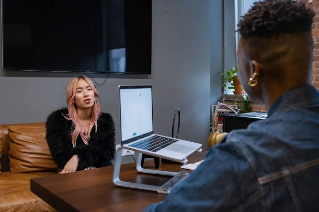 Transfeminine and non-binary colleagues talking in an office.